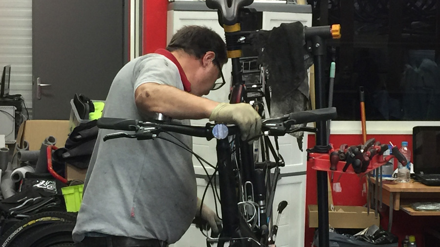 Laurent en train de réparer un vélo